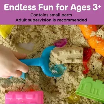 Child using blue scoop in kinetic sand with colorful molds and shell gems from beach-themed sensory bin for ages 3 and up.