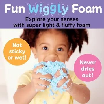 Child holding bright blue wiggly foam from mermaid sensory bin, demonstrating soft, non-sticky texture ideal for sensory play and tactile exploration