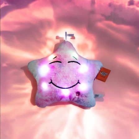 Pink plush star toy softly glowing with white and purple lights that create a calming projection on the pink background, perfect for sensory and bedtime comfort.